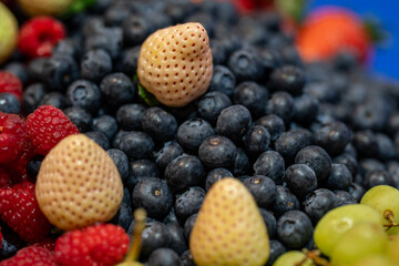 sample of black cranberries next to white strawberries