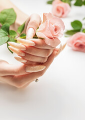 Female Hands on a white background with beautiful pearl manicure.Hands on a brown background and beautiful pearl manicure