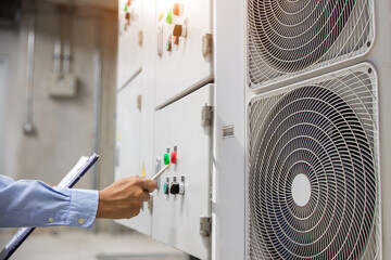 Electrical engineer checking electric at circuit breaker of air handling unit (AHU) starter control...