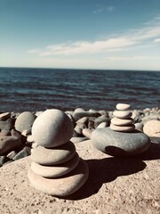 Balanced rock pyramid on pebbles beach, sunny day and clear sky at sunset