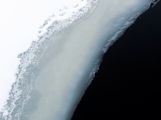 Thin ice on winter. Murky water under thin ice in Finland.