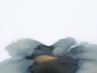 Thin ice on winter. Murky water under thin ice in Finland.