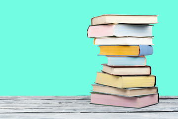 Open stacking book, hardback colorful books on wooden table and green background. Back to school. Copy space for text. Education business concept.