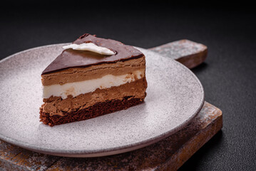 Piece of delicious sweet chocolate cake with sponge cake and cream