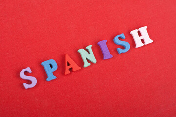 Fototapeta na wymiar SPANISH word on red background composed from colorful abc alphabet block wooden letters, copy space for ad text. Learning english concept.