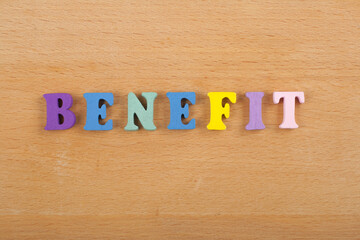 Naklejka premium BENEFIT word on wooden background composed from colorful abc alphabet block wooden letters, copy space for ad text. Learning english concept.