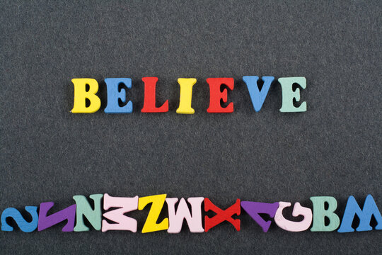 BELIEVE word on black board background composed from colorful abc alphabet block wooden letters, copy space for ad text. Learning english concept.