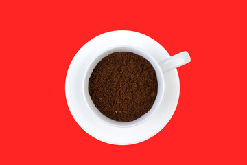 A cup of ground coffee isolated on a red background. top view.