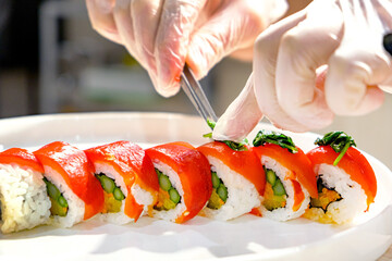 Male cook making sushi, asian kitchen