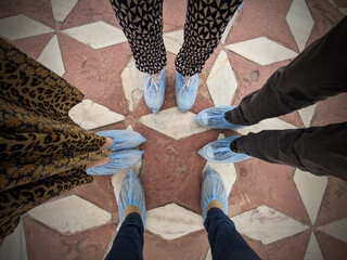 four friends ready to enter a temple or sacred place with shoe coverings on as a mark of respect...