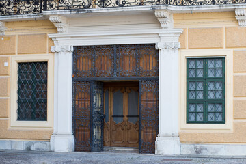 Large gate at the entrance to the building. Wooden doors with iron bars. Armored doors to the castle. The ceremonial entrance to the royal palace.
