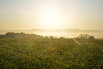 Early morning landscape with fog and sun