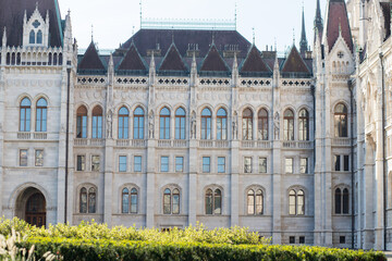 Fototapeta premium European Parliament in Budapest. Burgundy roof. Many windows in the facade of the building. Stylish window frames. Gothic in architecture.
