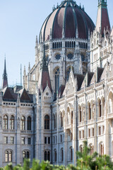 European Parliament in Budapest. Burgundy domes with high spiers. Gothic style in European architecture. Beautiful facade of the house. Large building. Architectural structure.