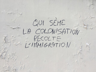 "colonialism is the cause of immigration" graffiti  in Paris, France