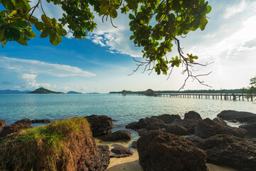 The wooden bridge in the sea at a tropical island with emerald green water and beautiful beaches.