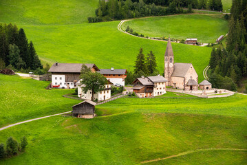 Mountain village in green valley in Dolomite alps in summer
