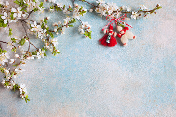 Decorative background for the text of congratulations on the holiday of March 1 Martisor, Baba Marta with flowering cherry plum branches, red and white martenitsa.
