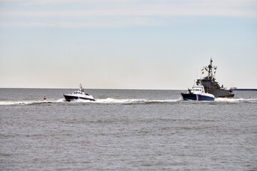 Coast guard ship escort russian warship that has trespassed state border along seaside, coast guard...