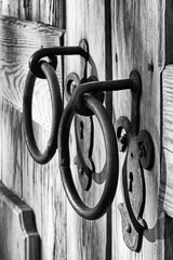 Old wooden door with two keyholes and two ring-shaped handles