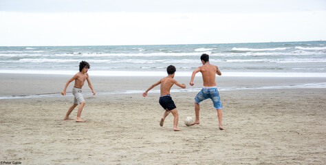 Fototapeta na wymiar Crianças jogando bola na praia