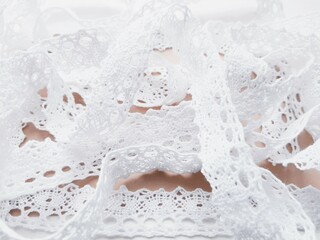 Soft background with tender white lace tape close up view.