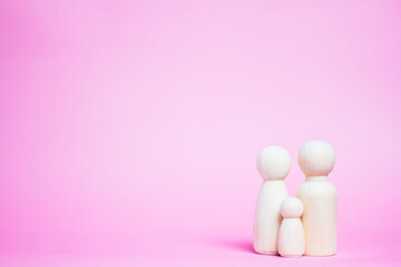 Family wooden puppets on pink background Life insurance ideas for future financial security and...