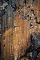 Texture of striped natural rough wild stone. The background of a stone structure of different shapes and colors with chips and cracks