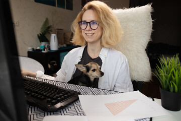 Home workspace, woman using computer, small dog companion, remote work,online shopping, gaming, internet banking