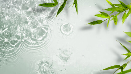 abstract fresh transparent water surface from above with a border of green bamboo leaves, beauty...