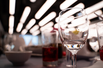 Water glasses and wine glasses on banquet table, bokeh light background