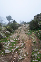 Fototapeta na wymiar An old granite stone path in the mountains on a foggy day. Mountains of Extremadura. A true landscape