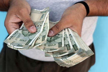 Man counting 500 rupee banknotes