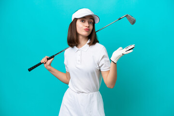 Young Ukrainian golfer player woman isolated on blue background having doubts while raising hands