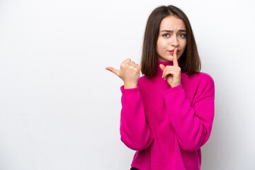 Young Ukrainian woman isolated on white background pointing to the side and doing silence gesture