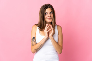 Young slovak woman isolated on pink background scheming something