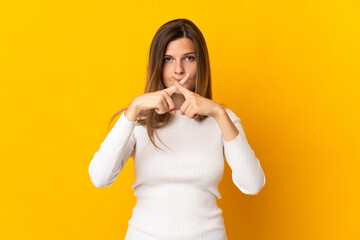 Young Slovak woman isolated on yellow background showing a sign of silence gesture