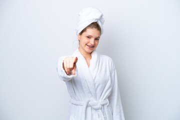 Teenager Russian girl in a bathrobe isolated on white background pointing front with happy expression