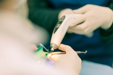 Detail of a dentist performing surgery with anesthesia on a patient for root canal treatment and...