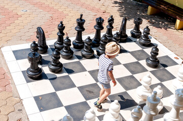 The boy is playing big chess