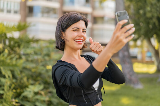 Young pretty Bulgarian woman at outdoors making a selfie with mobile phone