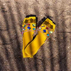 Close up of  colorful flip flops on beach under the palm tree