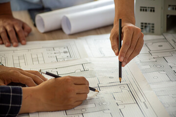 Professional cartographers working with cadastral map at table, closeup