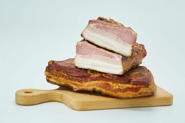 The meat dish is smoked bacon on a wooden board. The product is ready to use. White background.