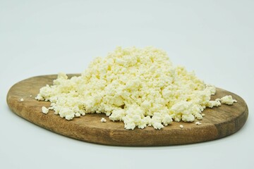 Cottage cheese on a wooden board. The product is ready to use. White background.