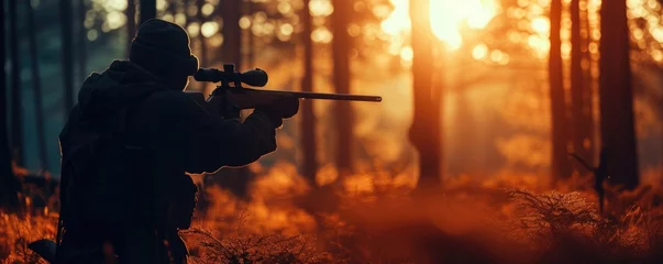 Foto op Plexiglas Hunter in holding rifle and shooting at evening forest. © Filip