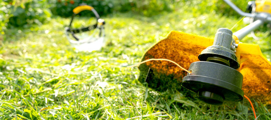 a man with a grass trimmer mows the grass