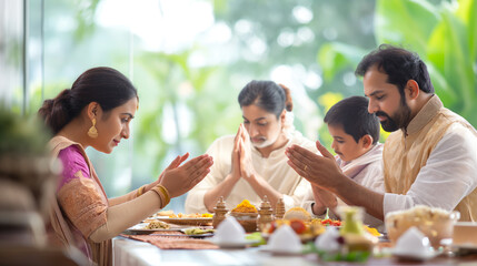 Indian family on dining table doing prayer before eating