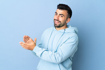 Caucasian man over isolated blue background applauding