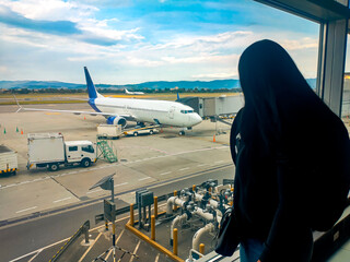 Latina Hispanic woman looking at an international plane at El Dorado airport in Bogotá, Colombia